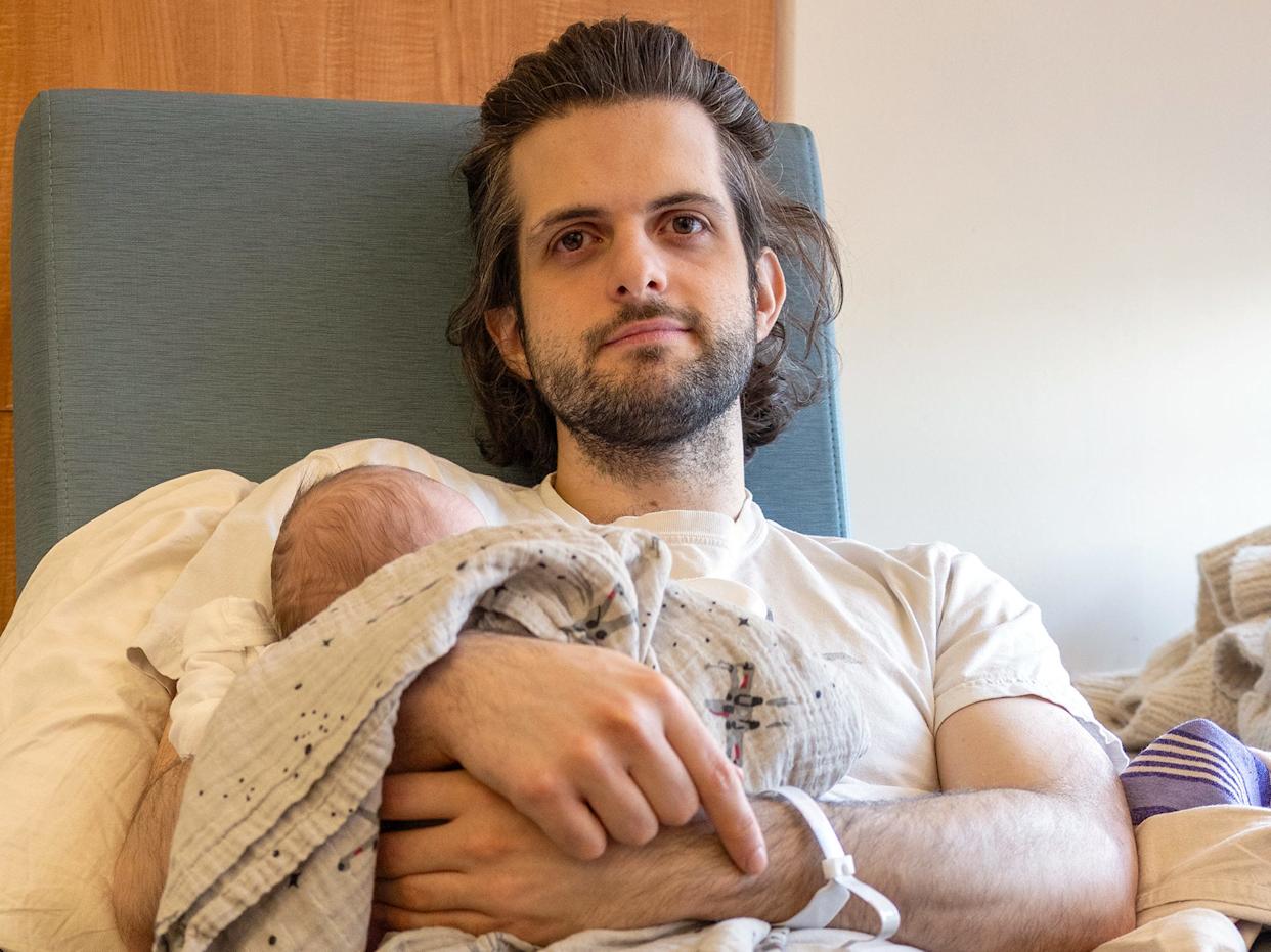 Zach Fox holding his newborn baby
