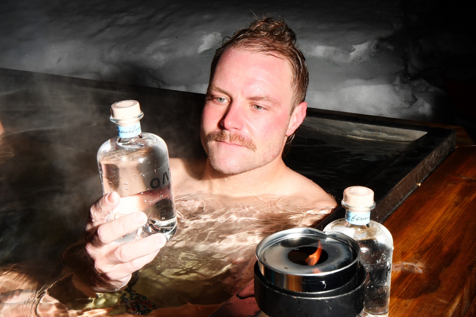 Bottas poses with a bottle of Oath Gin, the company he co-founded with partner Tiffany Cromwell