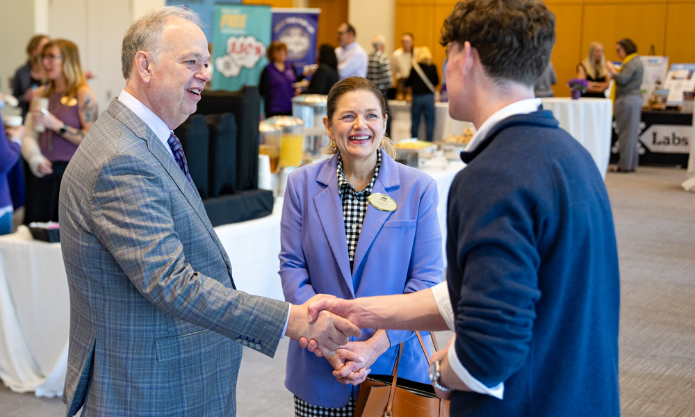 First lady Kim Schmidt and her husband, Dr. James C. Schmidt, greet a student.