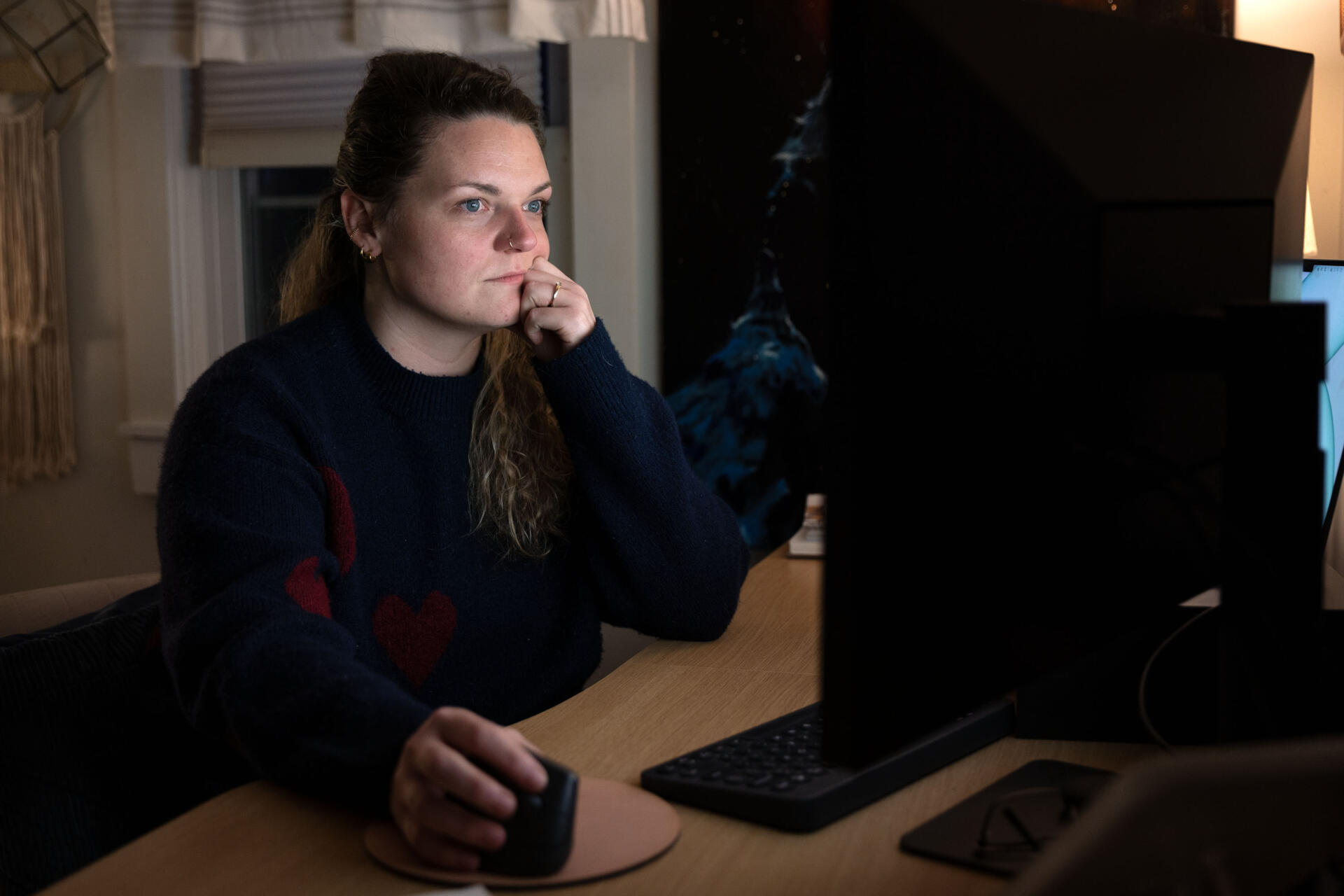 Suzi Sanford sits at her computer, using the AI chatbot Claude, at her home in Fitchburg, Mass. (Robin Lubbock/WBUR)