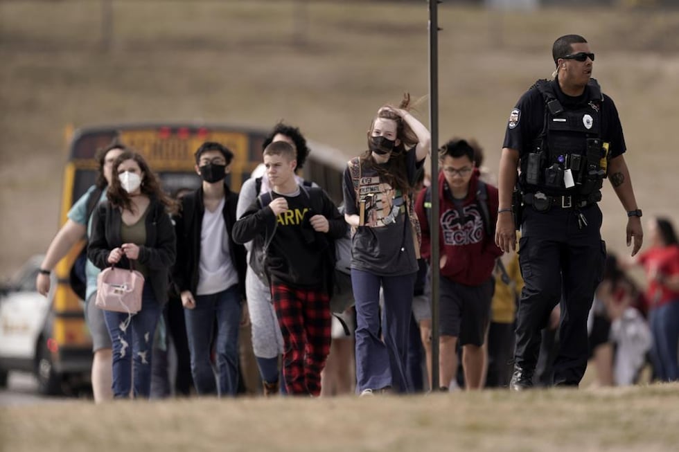 FILE - Students from Olathe East High School are lead to a staging area to reunite with their...