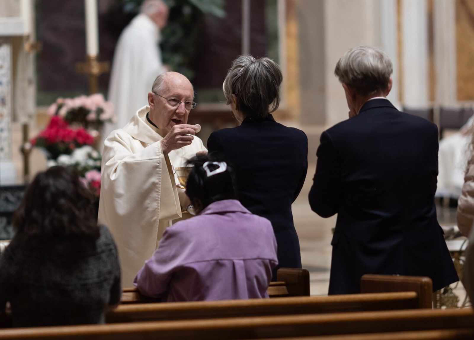 Msgr. W. Ronald Jameson, the rector of the Cathedral of St. Matthew the Apostle in Washington, gives Communion to a woman during a May 9 Mass where prayers were offered for people living with mental health challenges. (Catholic Standard photo by Rachel Lincoln)