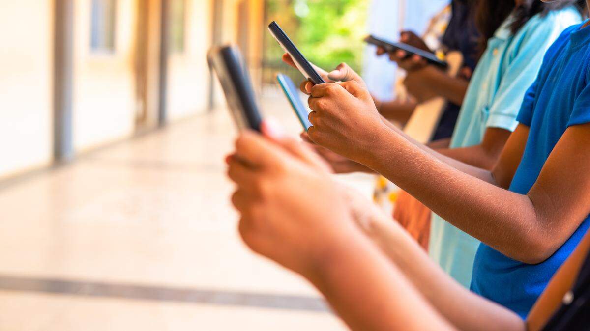Close up shot, group of children hands busy using smartphone at school corridor - concept of social media, playing games, technology and education. Close up shot, group of children hands busy using smartphone at school corridor - concept of social media, playing games, technology and education.