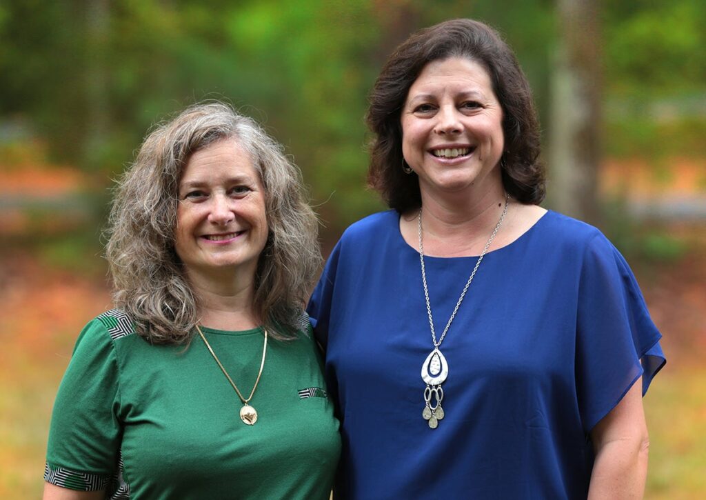 Jen Youngstrom (left) and Jennifer Kirby (right) smile at the camera.