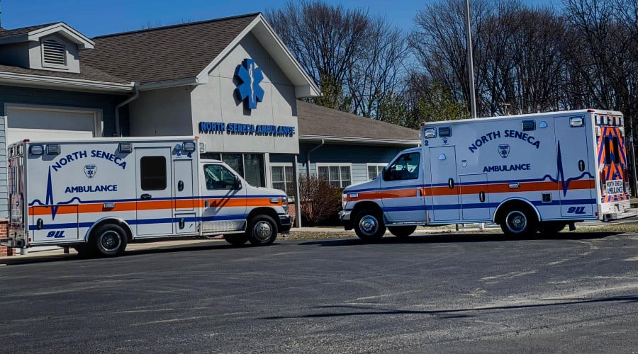 Two North Seneca Ambulance vehicles are parked outside their building on a sunny day.