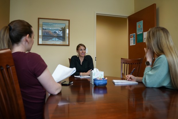 Summit County Deputy Coroner Britt Lea, center, meets with other coroner's office staff members, Annie McPeters, left, and Deborah Senecal, right, ahead of a grief support group meeting at their office on Tuesday, April 21, 2026, in Frisco. The group is free to Summit County residents. (Photo by Armando Geneyro/Special to The Colorado Trust)