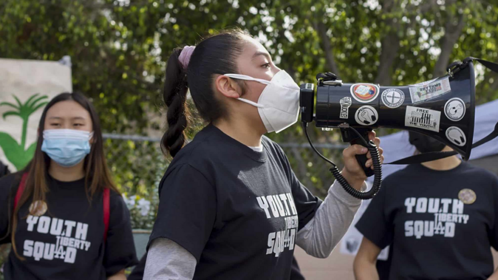 Members of the Youth Liberty Squad at a protest, with one student talking through a megaphone