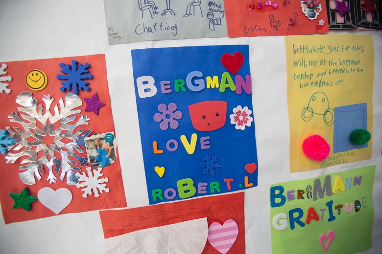 Colorful handmade posters and crafts decorate a wall at the Bergmann Center, featuring hearts, snowflakes, drawings and messages about friendship, gratitude and activities.
