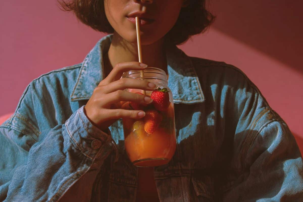This shows a woman drinking a fruit juice.