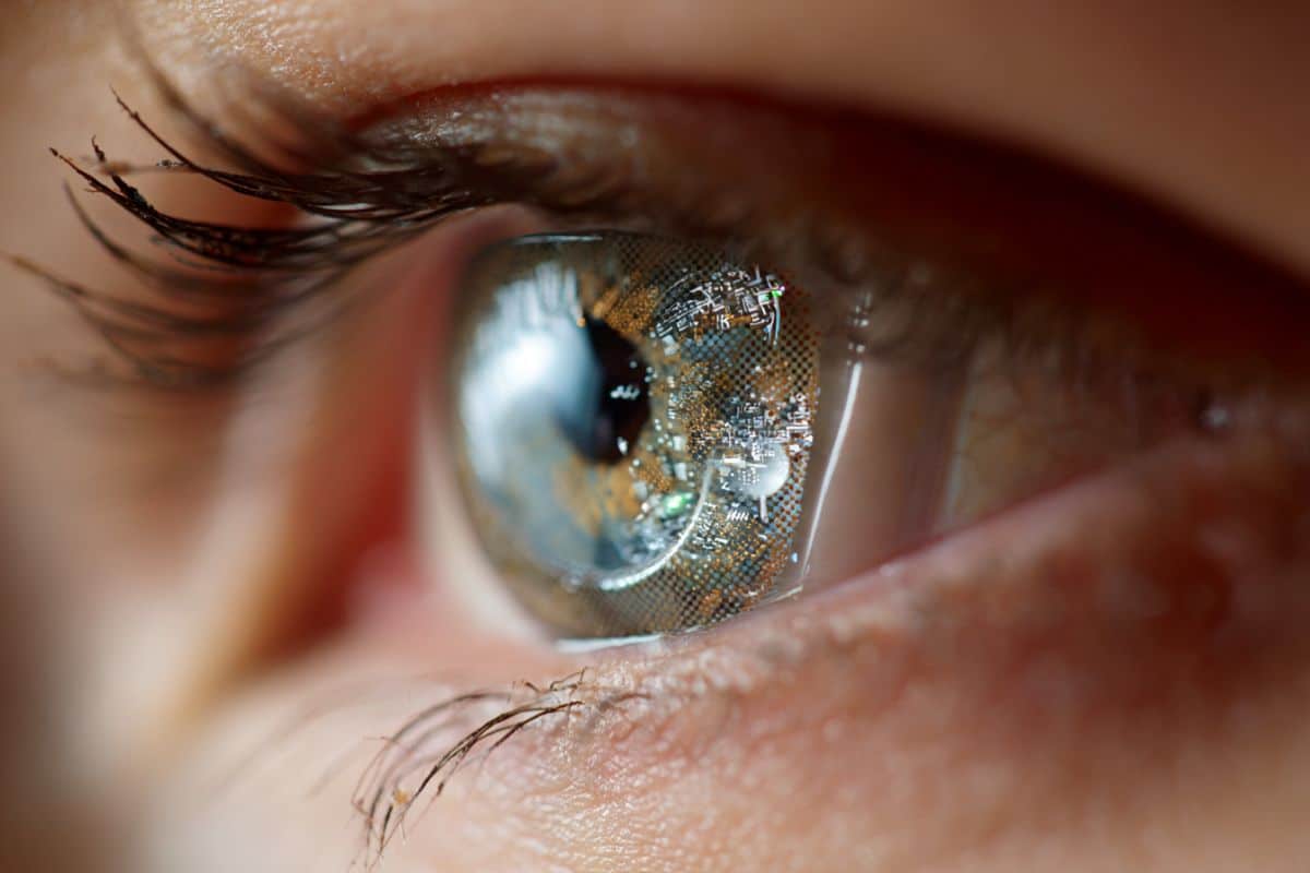 This shows a woman with a digital contact lense on her eye.