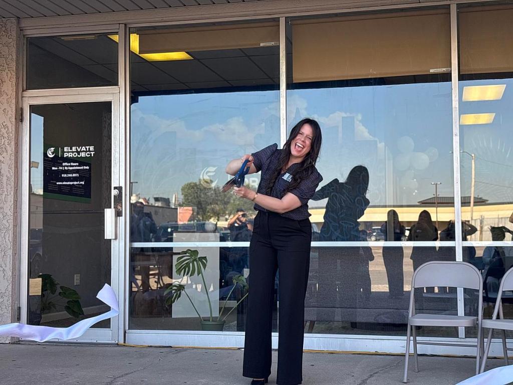 Brittne Canizales, founder and executive director, cuts a ribbon on March 26, 2026, to signal the grand opening for The Elevate Project. The organization aims to help youth on the eastside by providing bilingual therapy, group counseling, activities and more.
