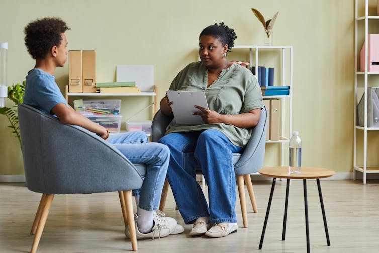 Teen boy and adult woman in counselling session