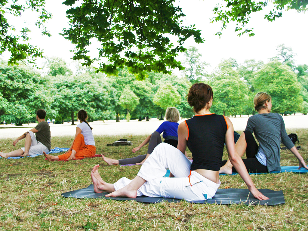 people doing yoga in a park