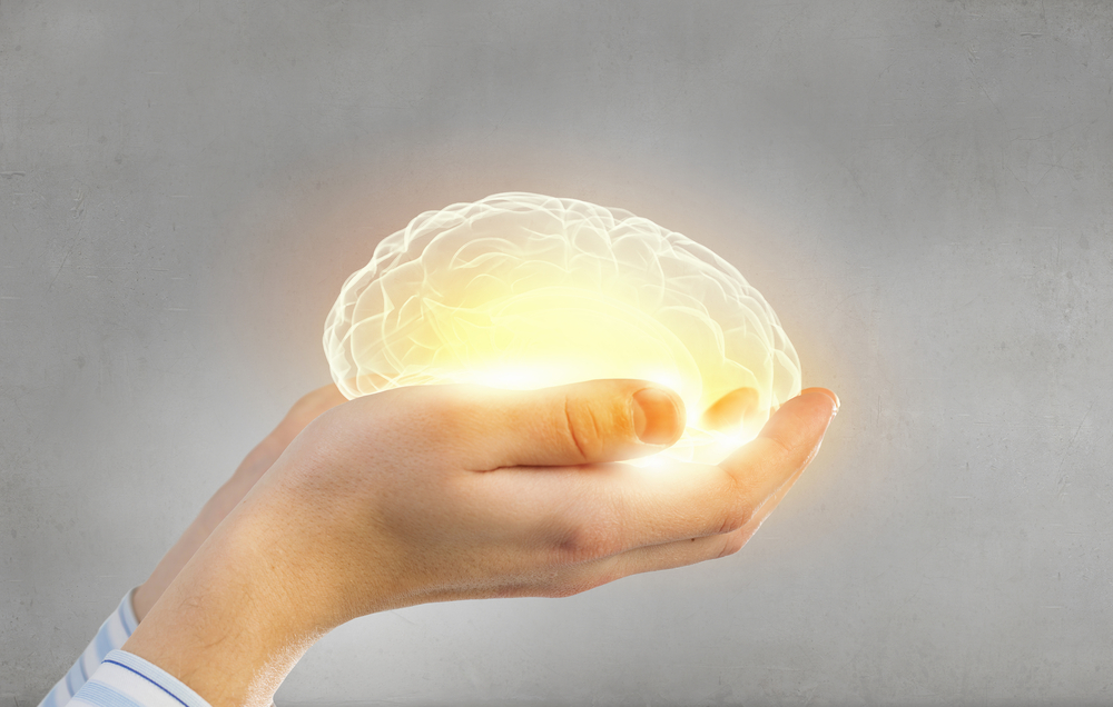 Glowing brain in outstretched hands.