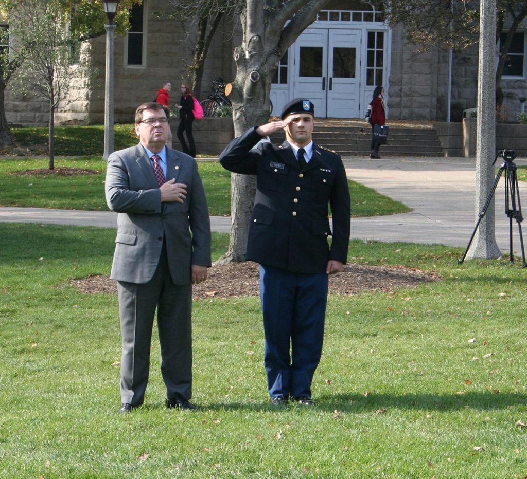 ROTC cadet joseph zolper salutes next to larry dietz on quad at Illinois State University