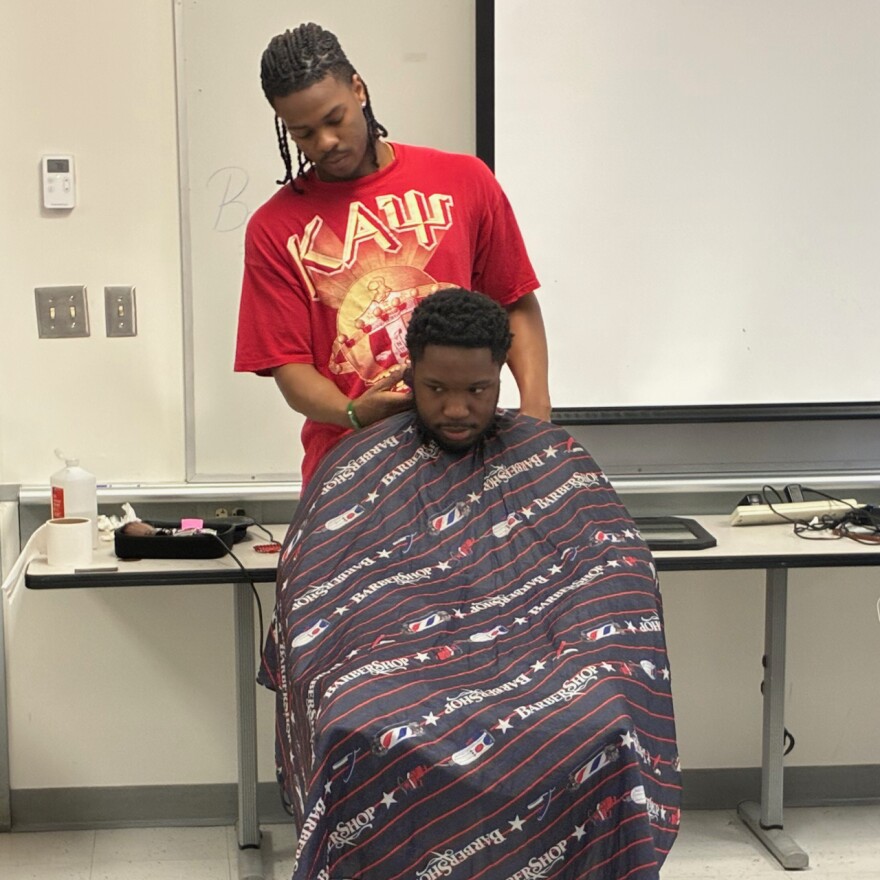 Justin Dawkins cuts a student’s hair at the Barbershop Talk event on April 14.