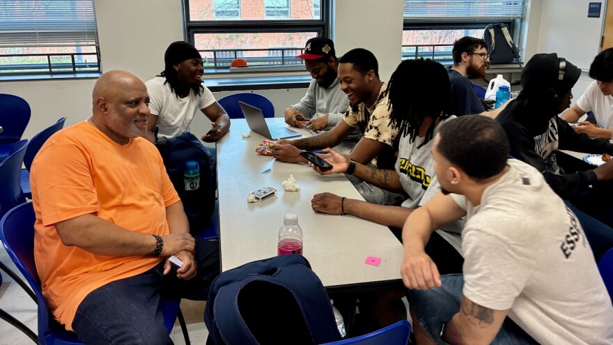 Bernard Macklin, left, with student customers at the Barbershop Talk event on April 14.
