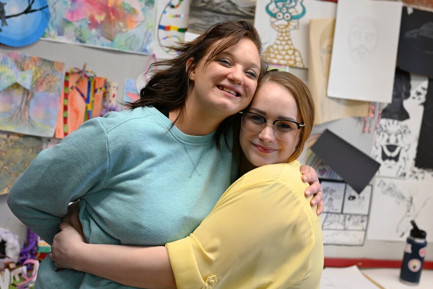 Two women embrace each other, smiling
