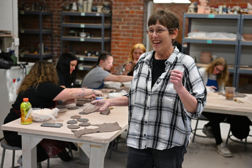 A woman instructs a pottery class