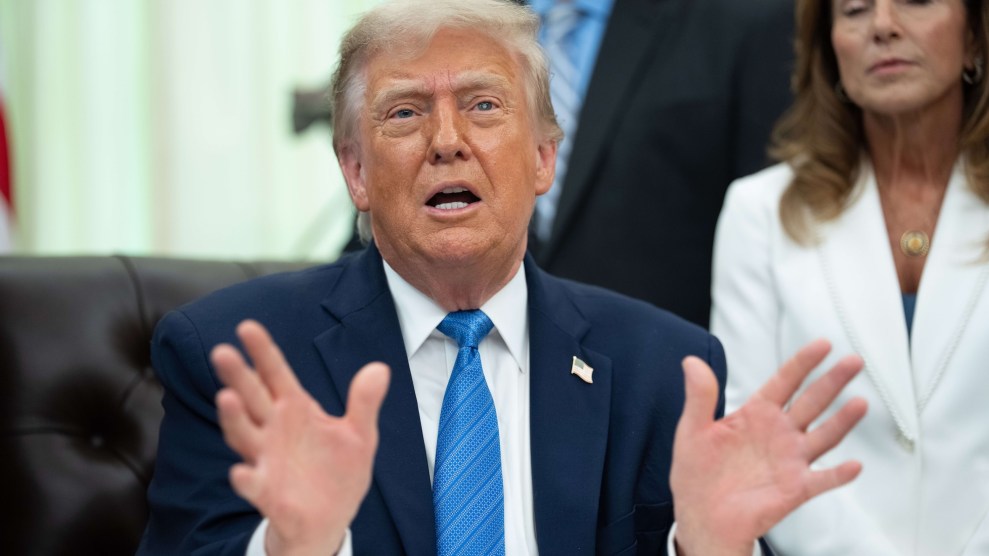 Donald Trump gesturing with his hands while sitting down on a chair.