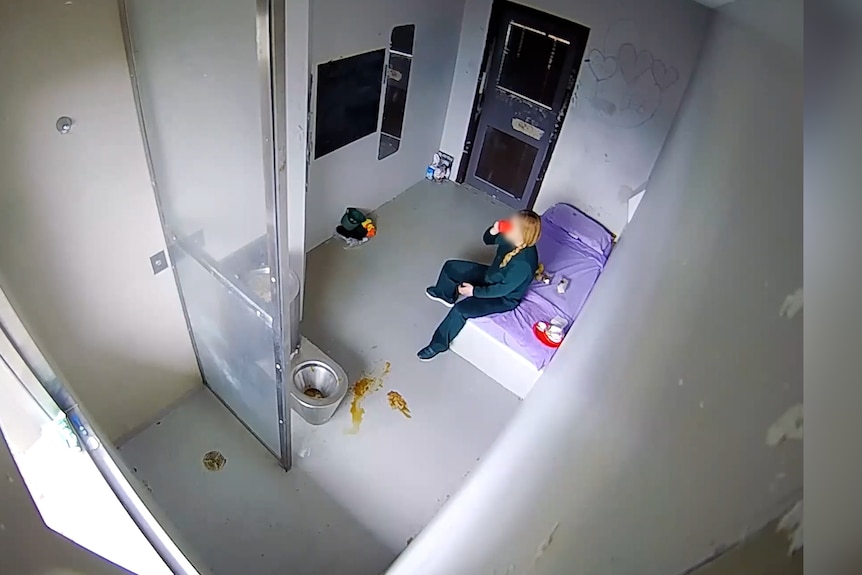 Tammy sits in a jail cell and holds a red plastic cup.