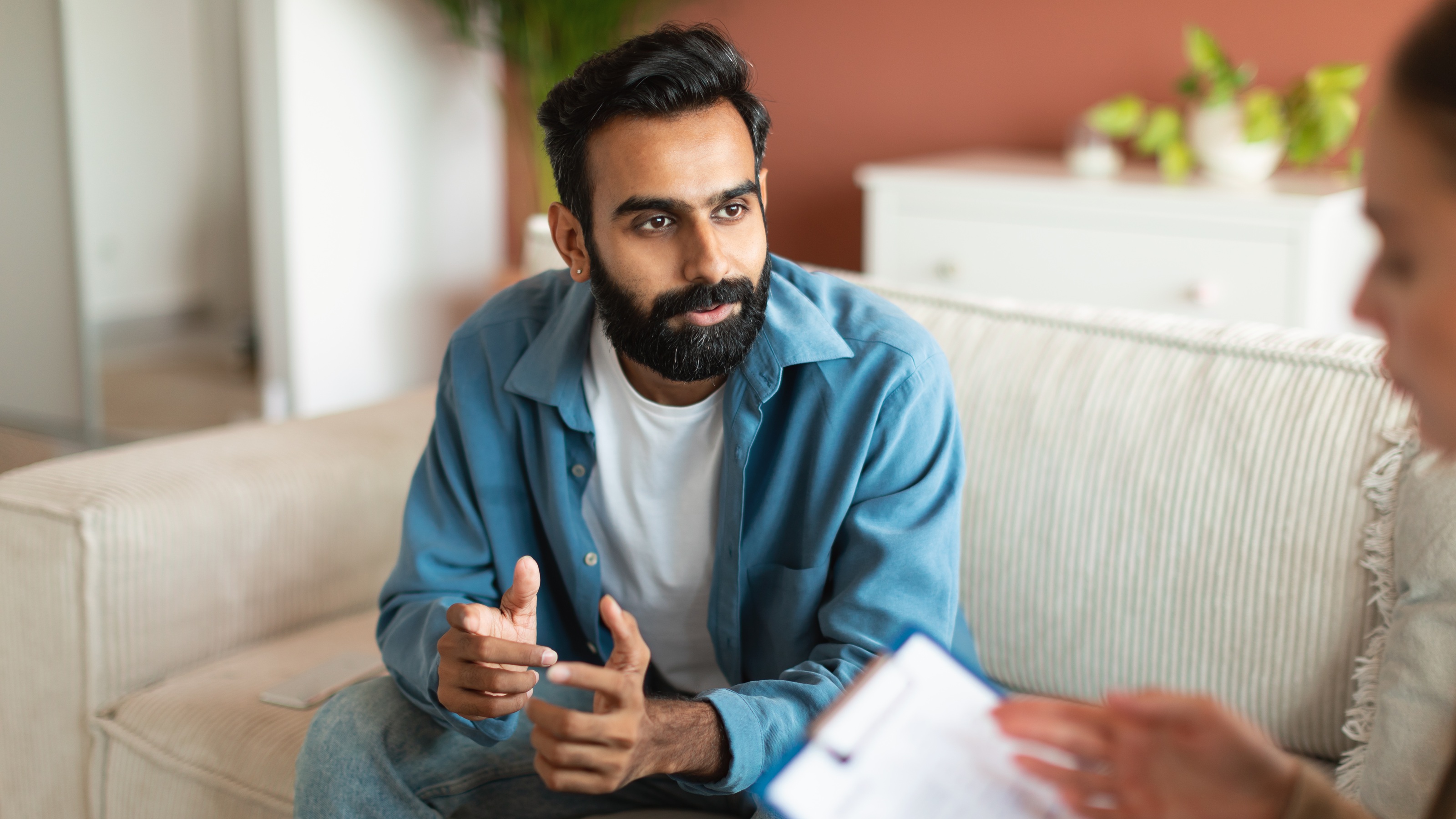 A man talks with a psychologist in her office.
