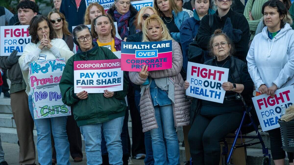 Healthcare workers hold signs at a “Fight for Our Health” rally at the Capitol on Wednesday, Jan. 14, 2026, in Sacramento. They were listening to Assemblymember Mia Bonta, chair of the Assembly Health Committee.