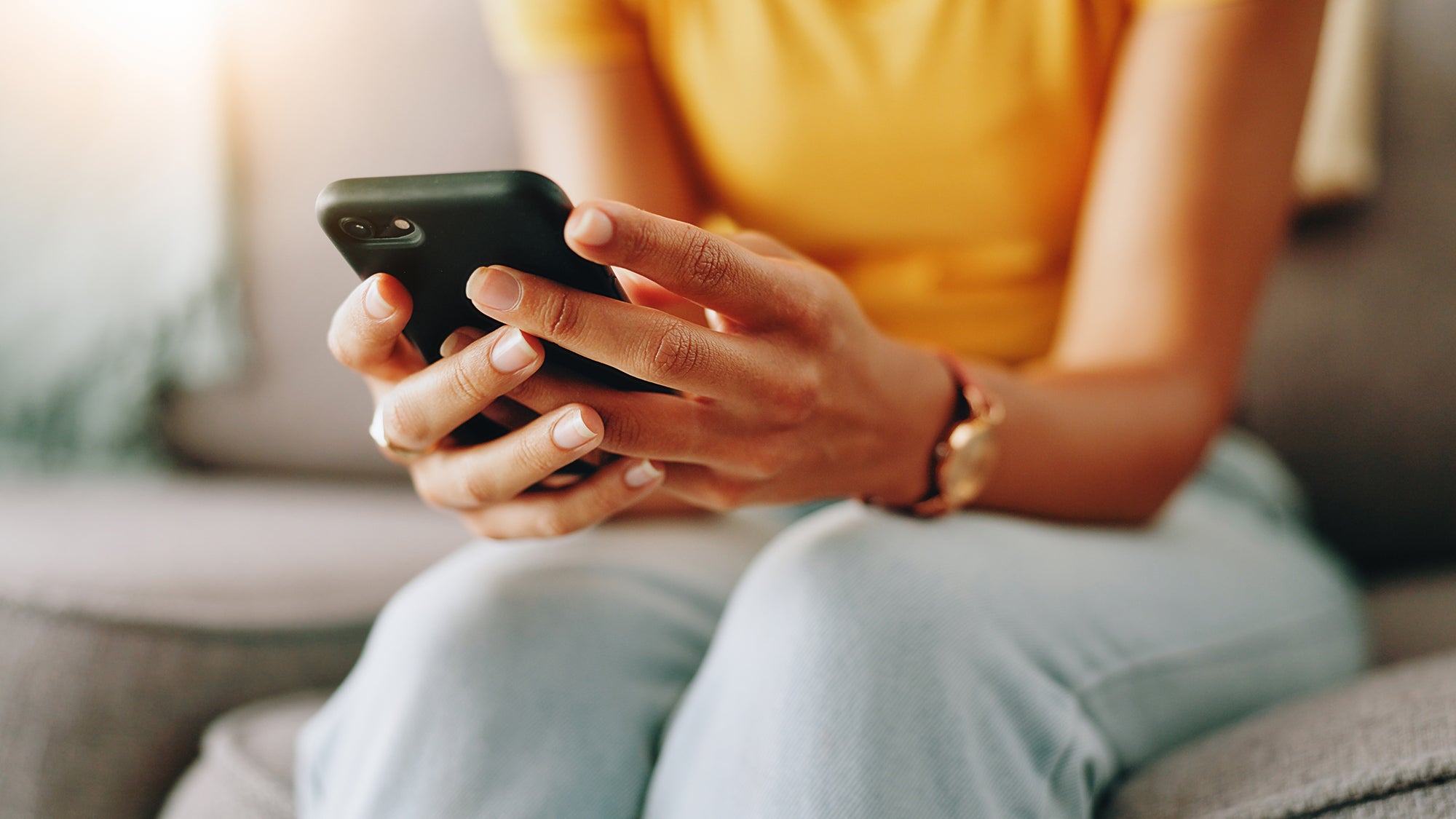 Woman sitting on a couch looking at her phone