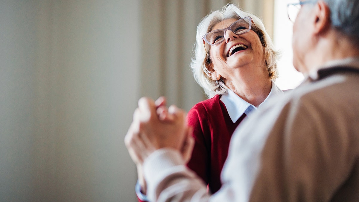 Elderly couple dancing together joyfully indoors