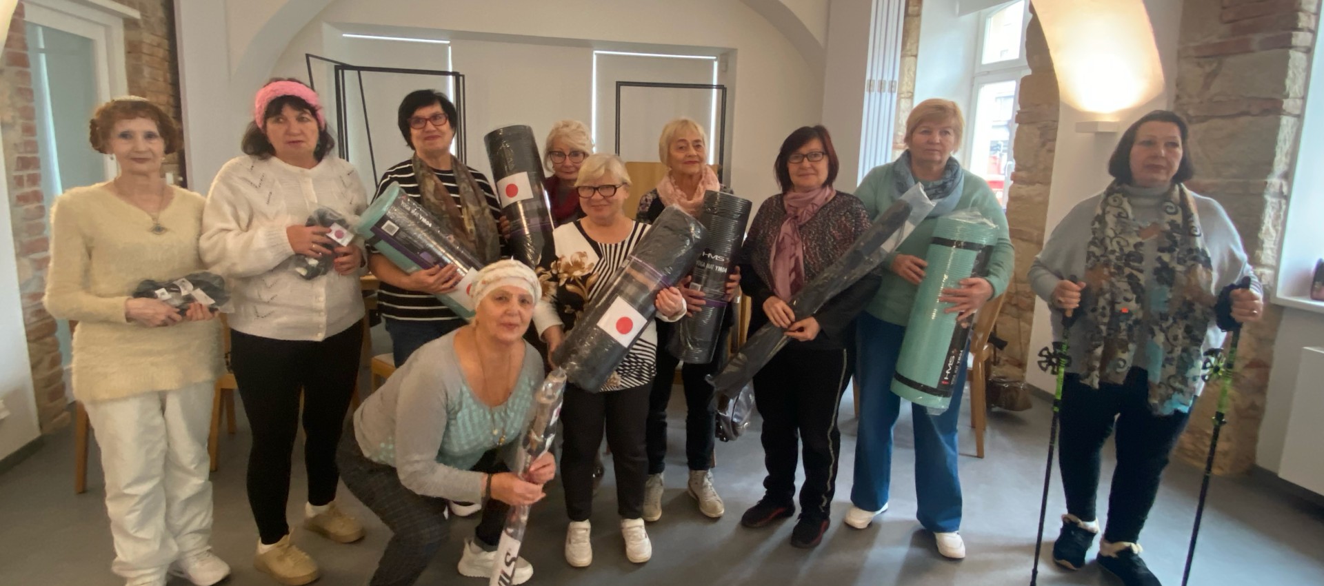 Older Ukrainian refugees receive mental health and psycho-social support in Czechia Older Ukrainian refugees in Czechia pose together after a community wellbeing session, holding yoga mats and walking poles provided to support physical activity.