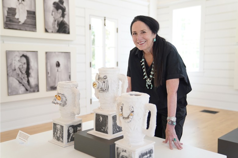 The artist Kimberly Chapman stands behind her piece, "Championship Cup Trophies to Male Medical Misogyny."